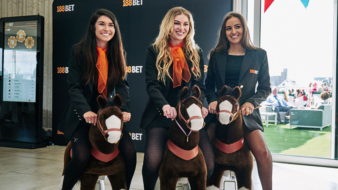 Adapt Events staff smiling on toy horses at Aintree Grand National